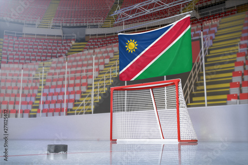 Flag of Namibia in hockey arena with puck and net