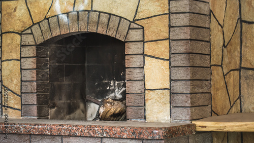 Concrete dirty fireplace with remains of ash after wooden firewood burnt in fireplace