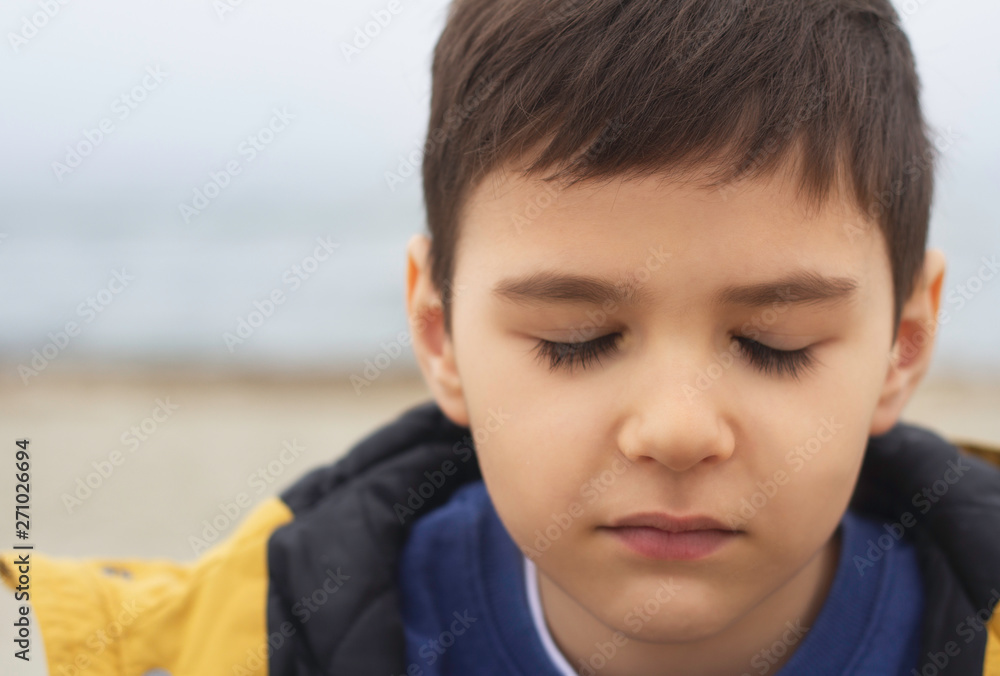 young boy with closed eyes on the background of the sea young boy with closed eyes on the background of the sea