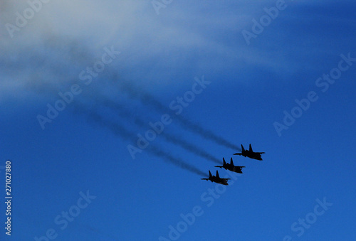 A group of fighters is flying in the blue sky