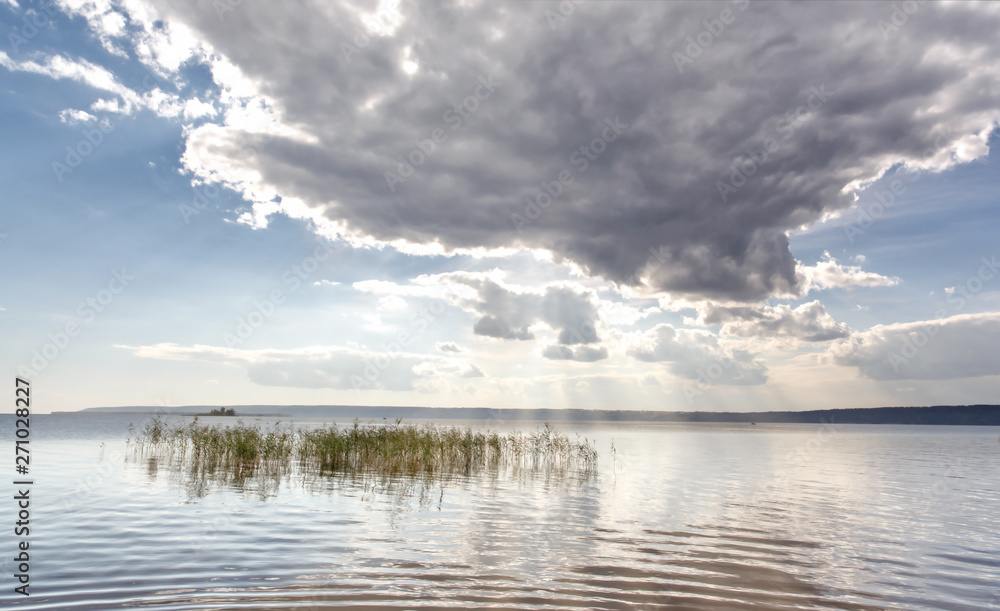 The sun's rays pierce through the thundercloud on the river. The sun's rays pierce through the thundercloud on the river.