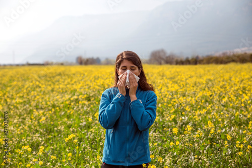 The woman polen allergy with yellow flowers.