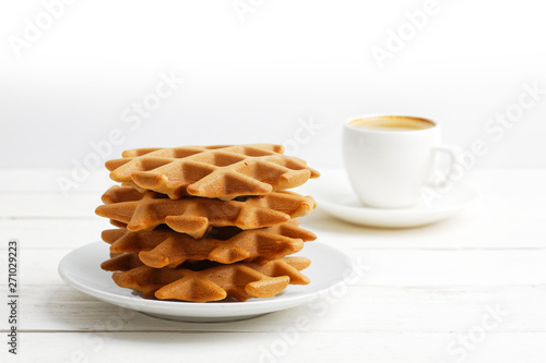 Homemade soft belgian waffles and cup of coffee on white wooden table. Shallow focus. Copyspace.