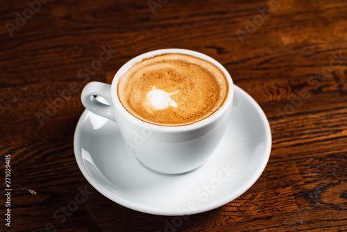 cup of cappuccino on the wooden background