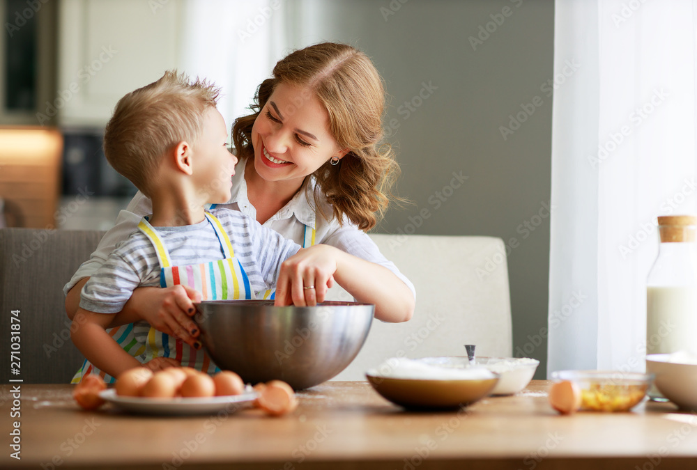 Happy family mother and son bake kneading dough in kitchen. Happy family mother and son bake kneading dough in kitchen.