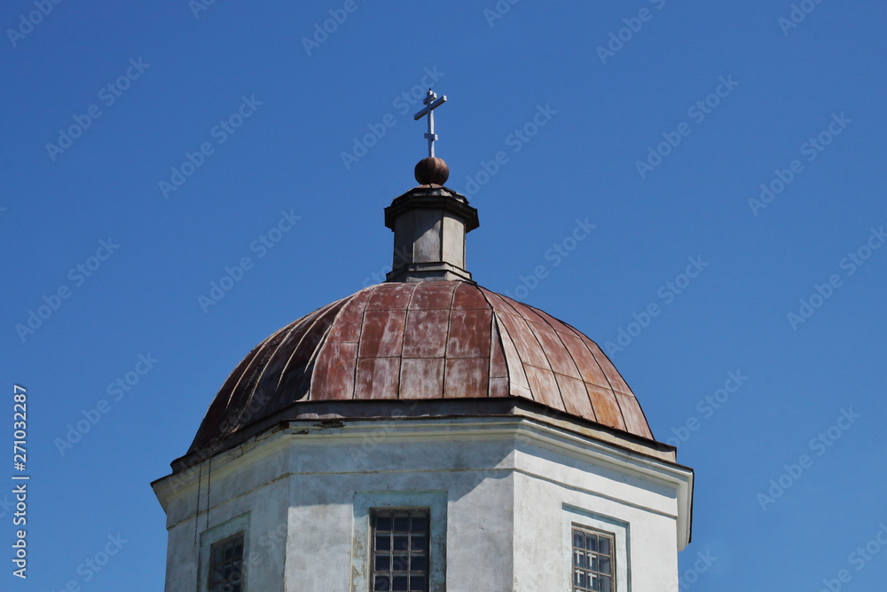 Dome with cross of Orthodox church of 19th century on background of clear blue sky. Symbolic concept — faith, religion, Christianity.