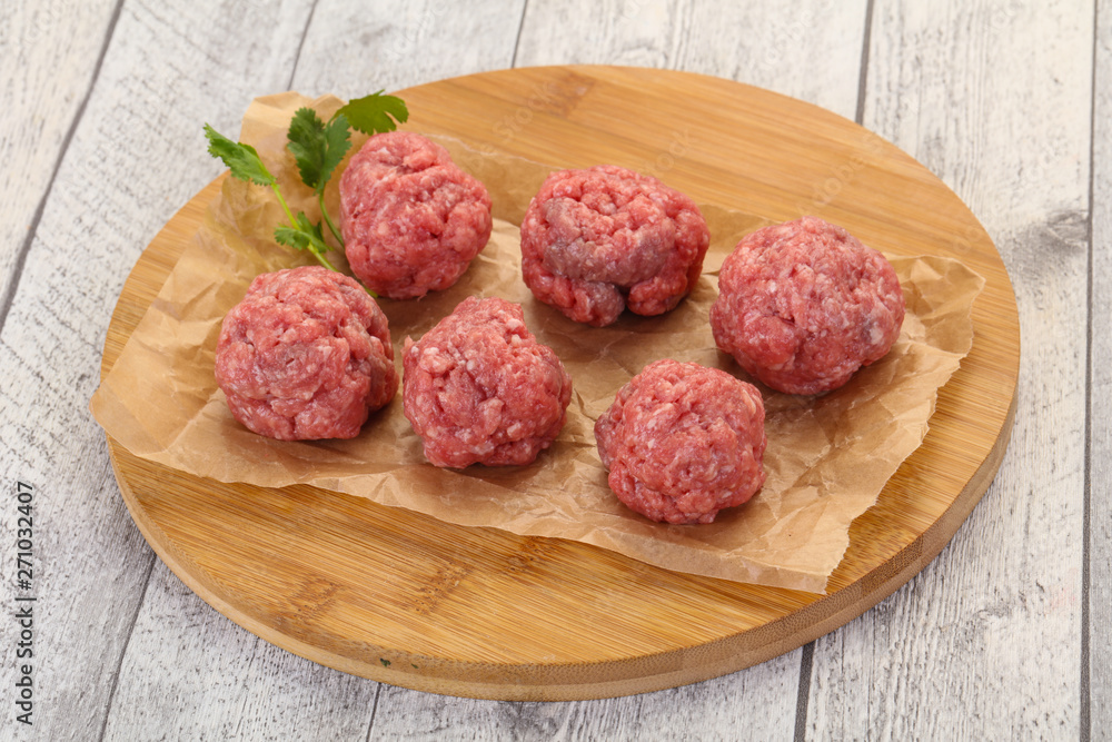 Raw meatball over wooden background Raw meatball over wooden background