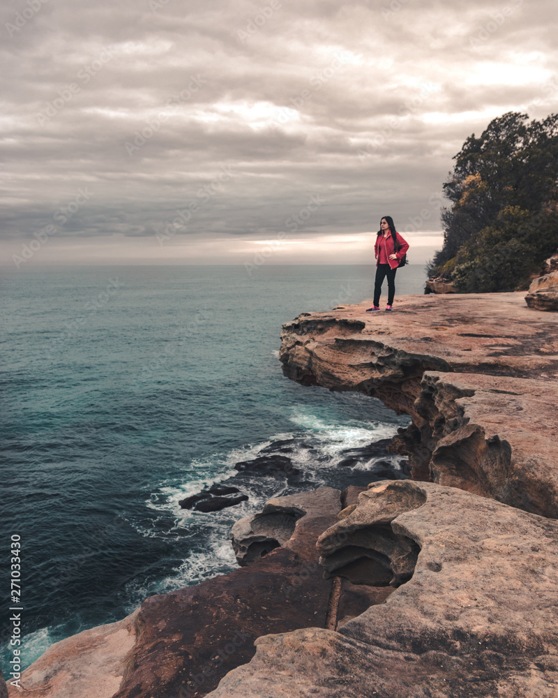 woman on the cliff overlooking the beach