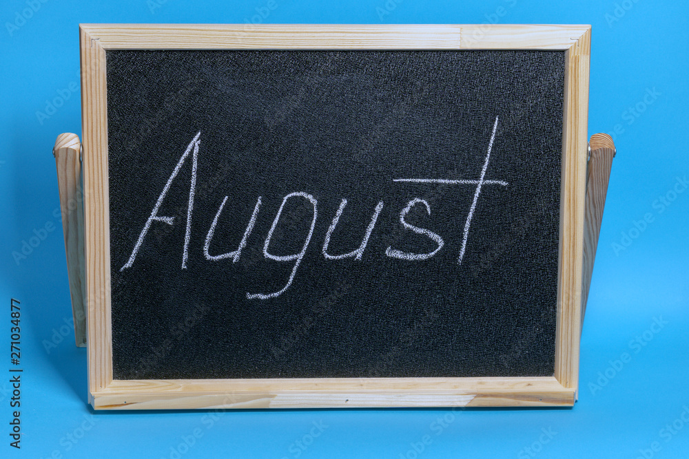 Blackboard with the word chalked august on blue background Blackboard with the word chalked august on blue background