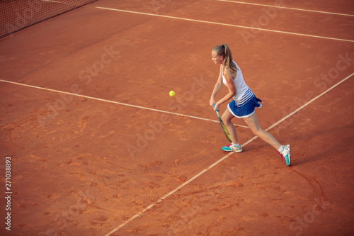 Woman playing tennis on clay court, with sporty outfit and healthy lifestyle © FS-Stock