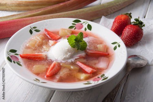 Rhubarb soup with strawberries and ice cream in