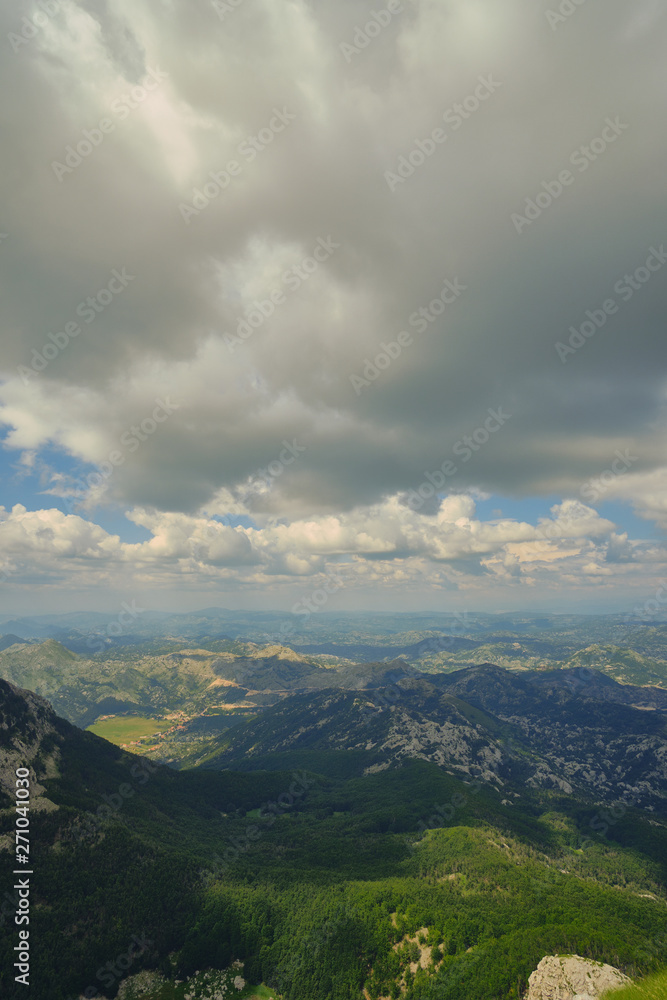 View from the mountain peak Lovchen on a sunny day. Blue sky with clouds, a bird's eye view.