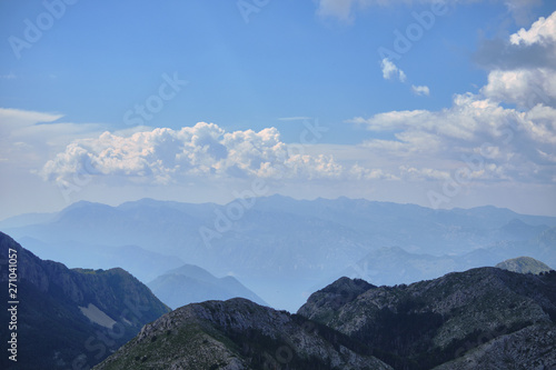 View from the mountain peak Lovchen on a sunny day. Blue sky with clouds, a bird's eye view.