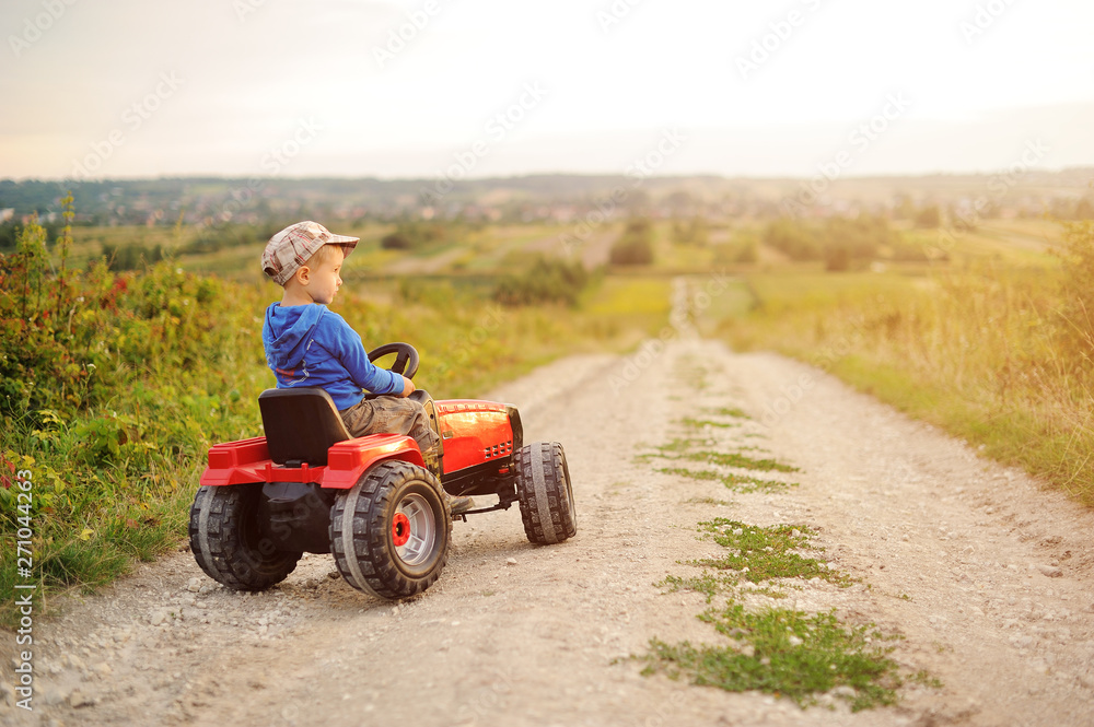 Child with a toy tractor on a trip.