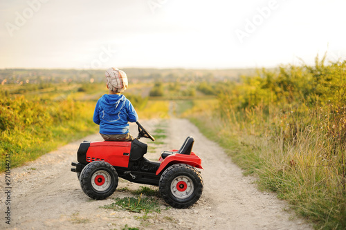 Child with a toy tractor on a trip.