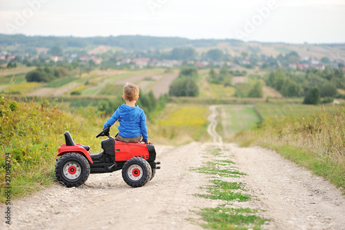 Child with a toy tractor on a trip.