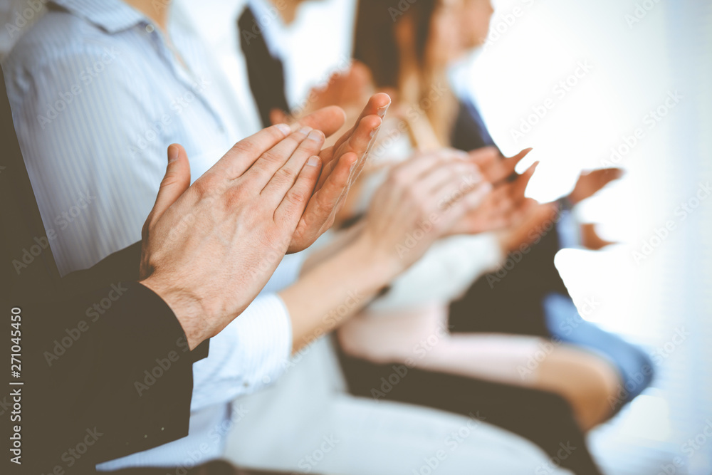 Business people clapping and applause at meeting or conference, close-up of hands. Group of unknown businessmen and women in modern white office. Success teamwork or corporate coaching concept Business people clapping and applause at meeting or conference, close-up of hands. Group of unknown businessmen and women in modern white office. Success teamwork or corporate coaching concept