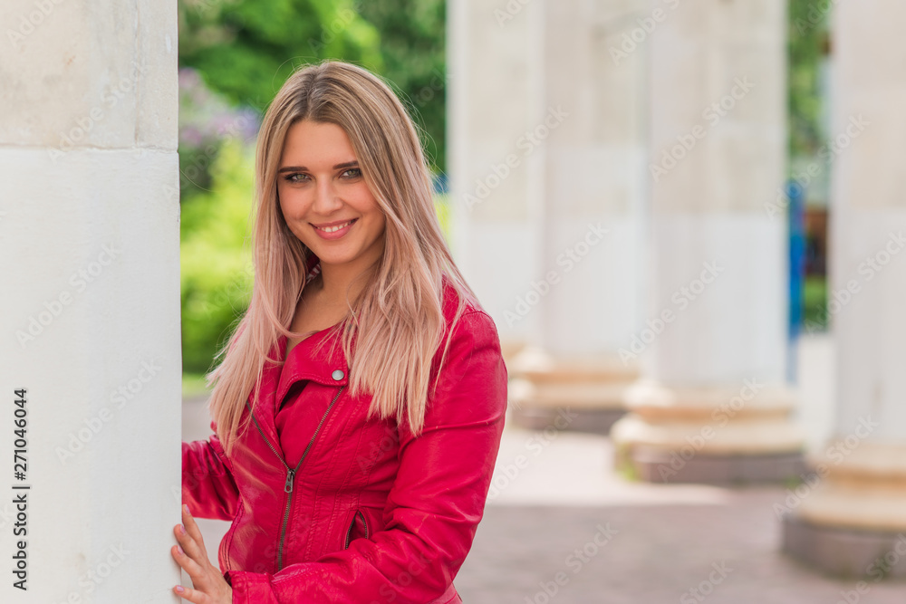 Nice stylish woman on a nature at park. Casual fashion, leather jacket elegant look. Plus size model. Happy overweight woman at the town 