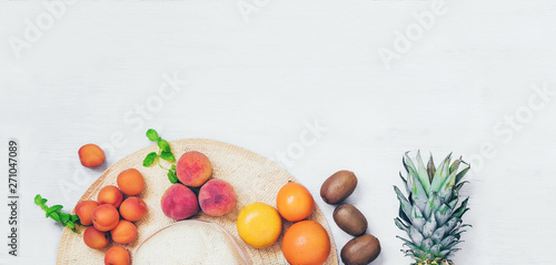 Summer concept  banner female hat with fruit on wooden table top view