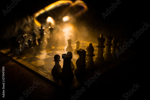 Chess board game concept of business ideas and competition. Chess figures on a dark background with smoke and fog.