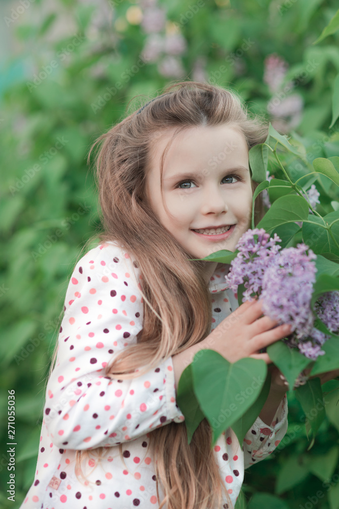 Spring portrait of beautiful smiling little girl with lilac flowers. Spring portrait of beautiful smiling little girl with lilac flowers.