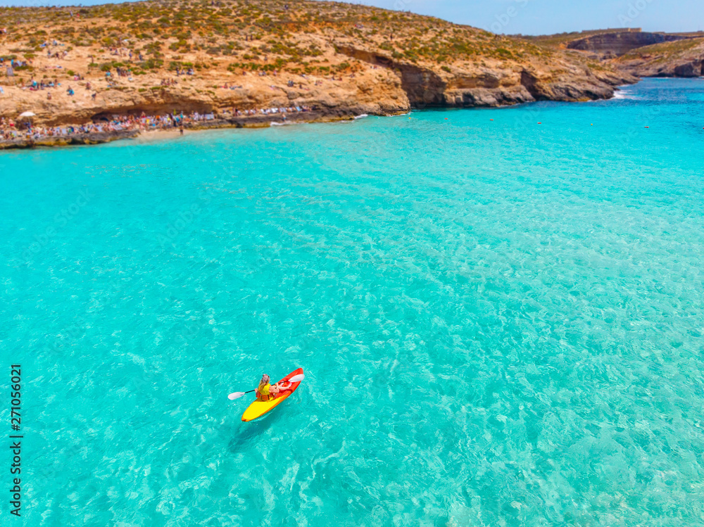 Kayak boat turquoise Blue Lagoon Comino Malta water sea, sunny day. Concept travel. Aerial top view