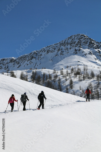 Hiking on snowshoes on a trail. Chamois, Valle D'Aosta, Italy.