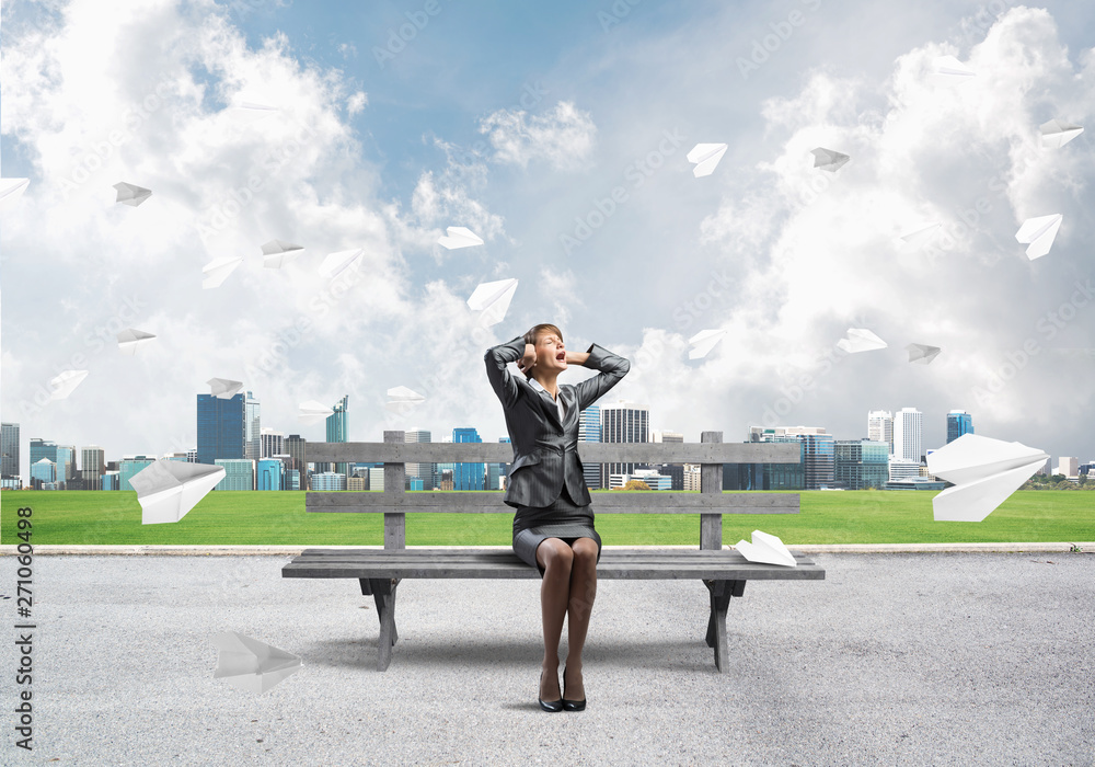 Stressful woman sitting on wooden bench Stressful woman sitting on wooden bench