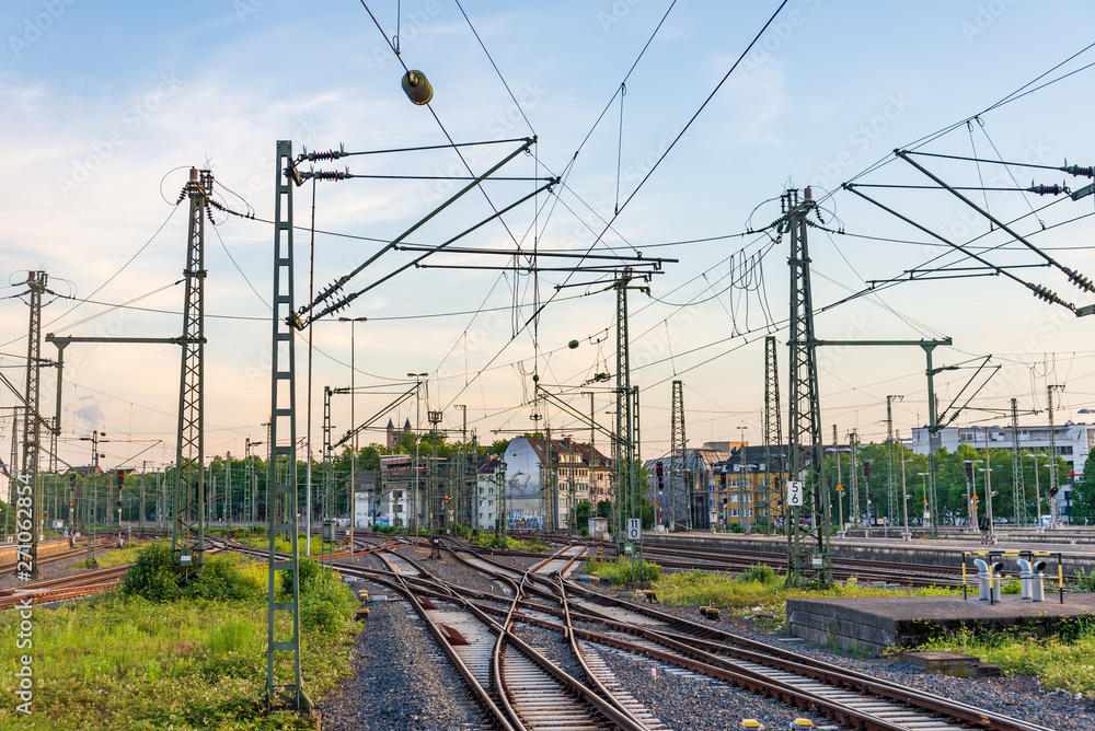 Outdoor view of straight and curve railway track lines without train at train station with mess complex electric cables and poles with golden light atmosphere against evening before sunset sky. Outdoor view of straight and curve railway track lines without train at train station with mess complex electric cables and poles with golden light atmosphere against evening before sunset sky.