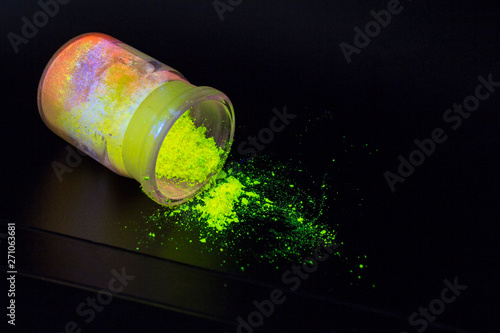 Luminescent organic materials in the form of a powder inside a glass bottle.