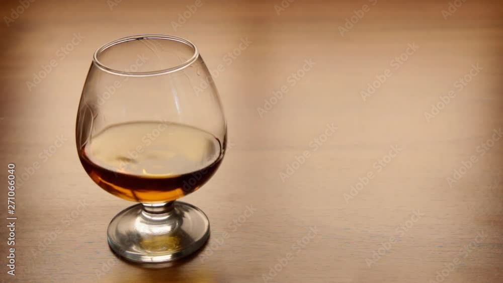 Movement of cognac in a glass standing on a table Movement of cognac in a glass standing on a table