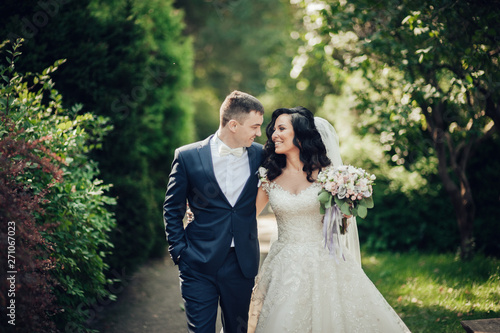 Beautiful bride and groom embracing and kissing on their wedding day.