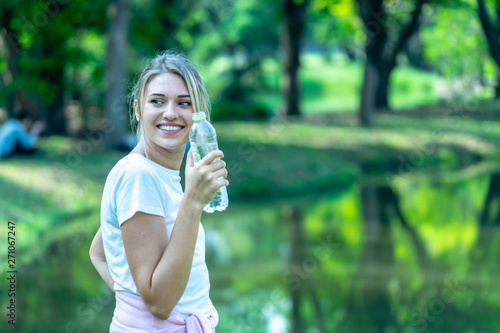 Woman smiling in White T-shirt holding Pet Plastic bottle © jiradet_ponari