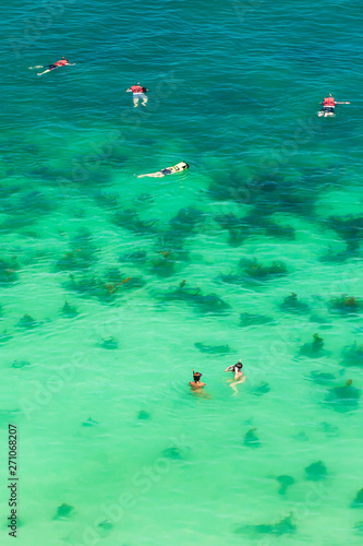 Aerial view of tourists snorkelling in a tropical sea.