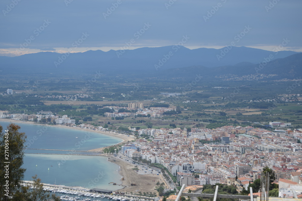 View of the sea and a small town on a hill near the coast.