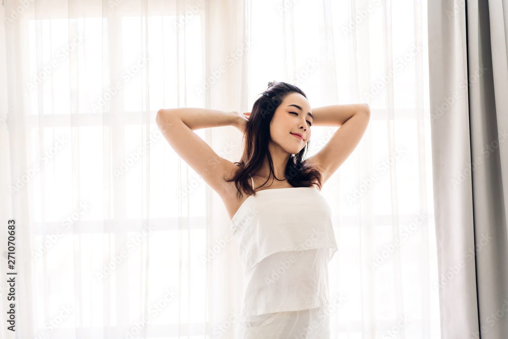 Woman stretching happy and relaxed after wake up in the morning at home Woman stretching happy and relaxed after wake up in the morning at home