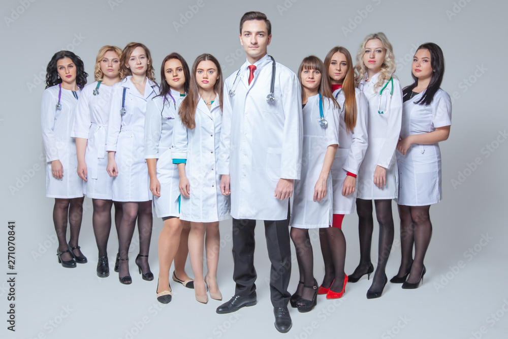 Full length portrait of an attractive male doctor staying at the head of group of doctors Full length portrait of an attractive male doctor staying at the head of group of doctors
