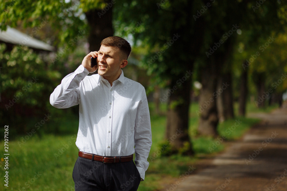Young man talking on the smartphone in the park Young man talking on the smartphone in the park