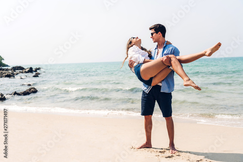 Romantic lovers young couple relaxing together on the tropical beach.Man hugging with woman and enjoy life.Summer vacations