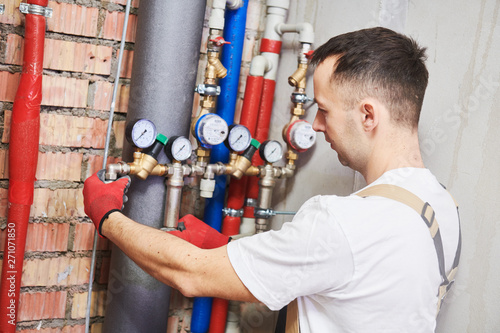 Φωτογραφία plumber installing and mounting water equipment - meter, filter and pressure red