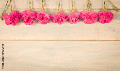 Floral background. Carnation flowers on a wooden background. A place for an inscription.