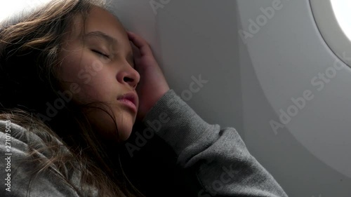 Tired young tween girl sleeping on airplane
