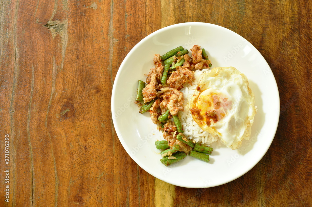 spicy stir fried pork with yard long bean curry topping egg on rice