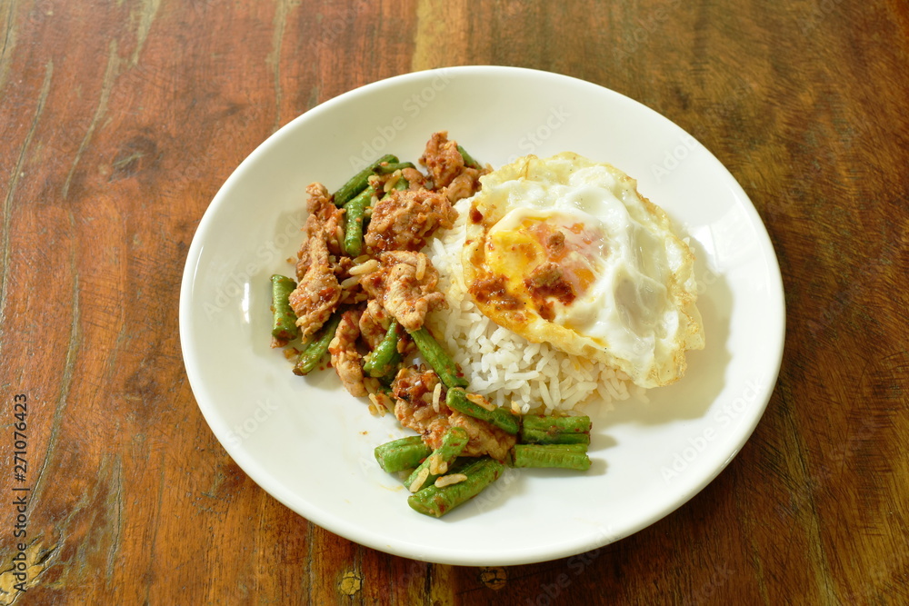 spicy stir fried pork with yard long bean curry topping egg on rice spicy stir fried pork with yard long bean curry topping egg on rice