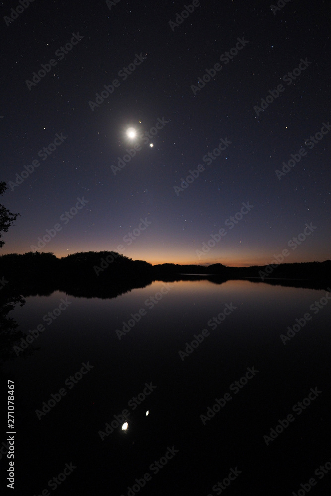The Moon and Venus over an exceptionally calm Paurotis Pond in Everglades National Park, Florida in late twilight.