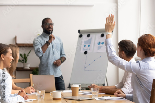 Young caucasian employee interrupts african american male mentor giving presentation