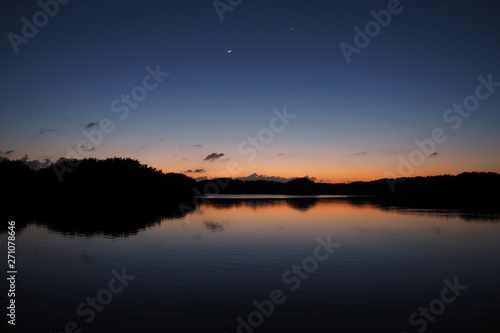 The Moon and Venus over an exceptionally calm Paurotis Pond in Everglades National Park  Florida in late twilight.