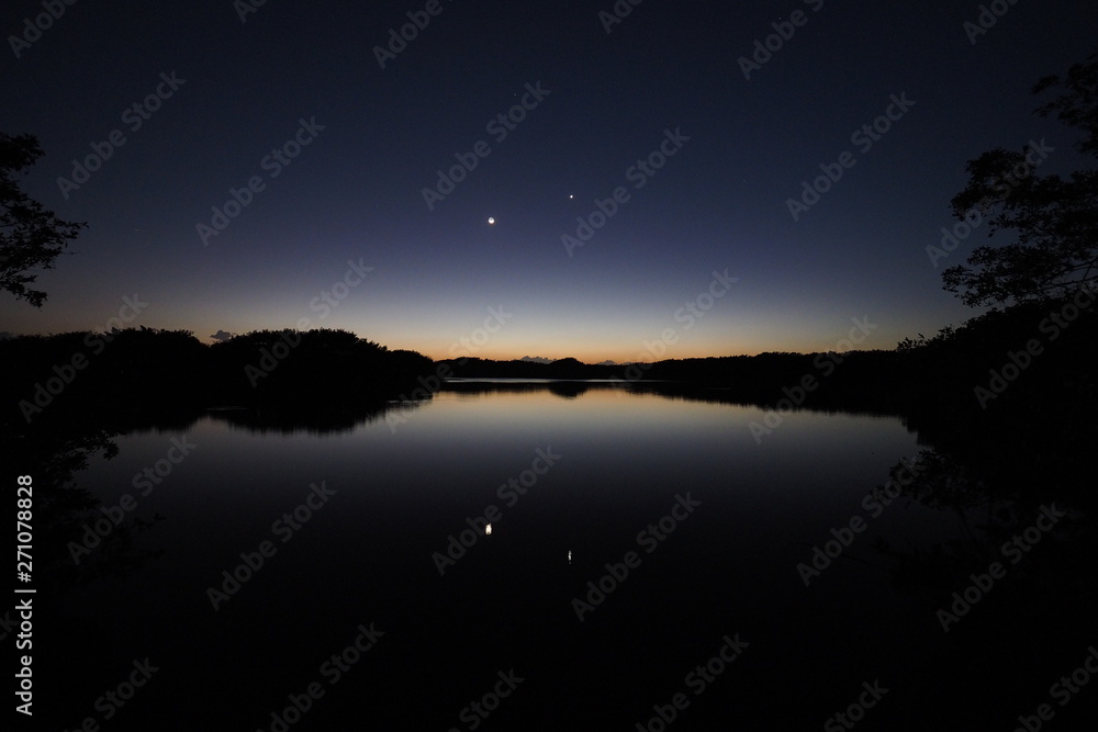 The Moon and Venus over an exceptionally calm Paurotis Pond in Everglades National Park, Florida in late twilight. The Moon and Venus over an exceptionally calm Paurotis Pond in Everglades National Park, Florida in late twilight.