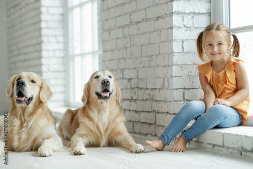 Child girl with dog at home 