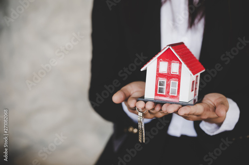Real estate agent with house model and keys